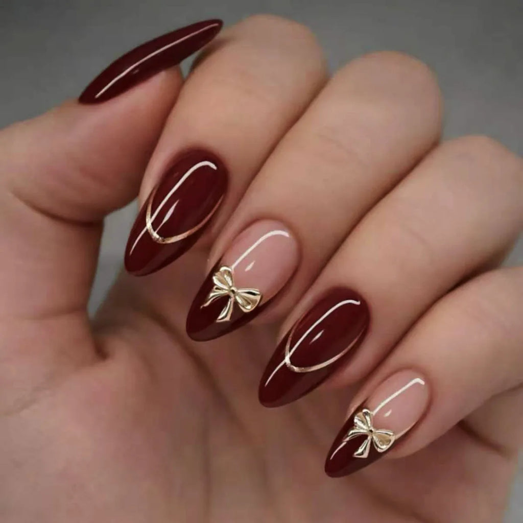 24 handmade almond nails. Burgundy base with nude French, white lines & metal bows. Reusable, elegant retro style for daily wear